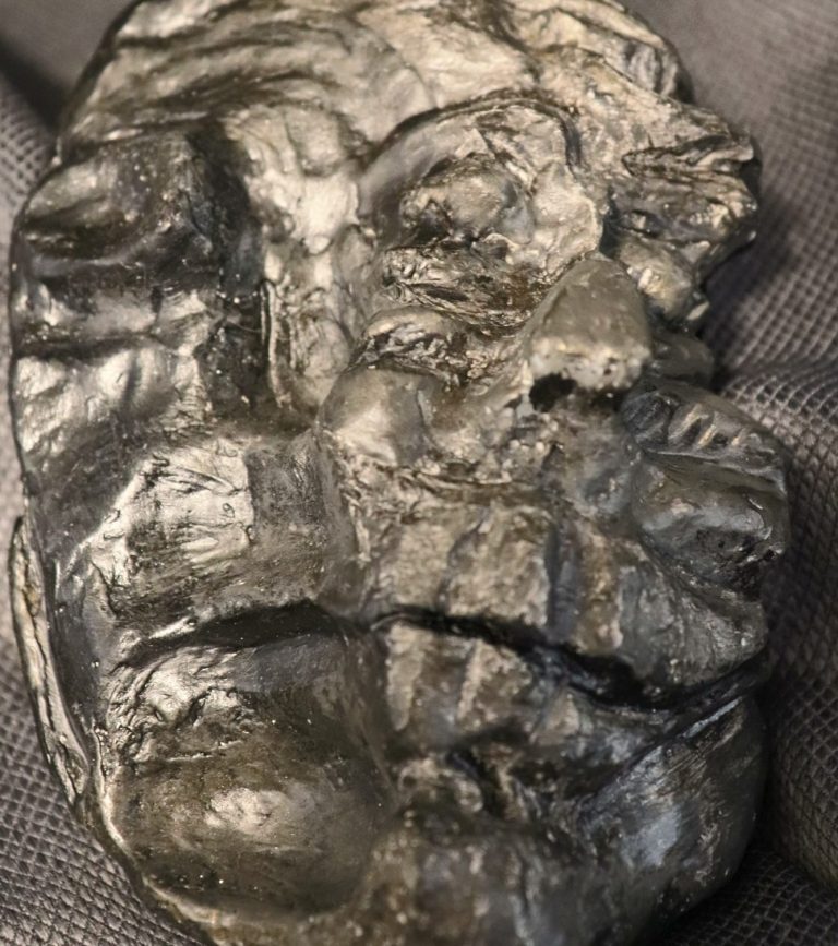 FACES – Main Frontal View Frontal view of the 'FACES' sculpture showing distorted features and raw texture